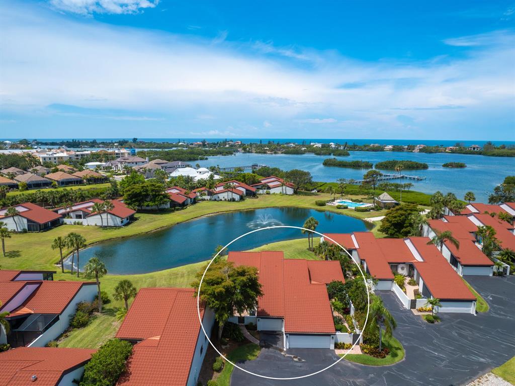 an aerial view of residential houses with outdoor space and lake view