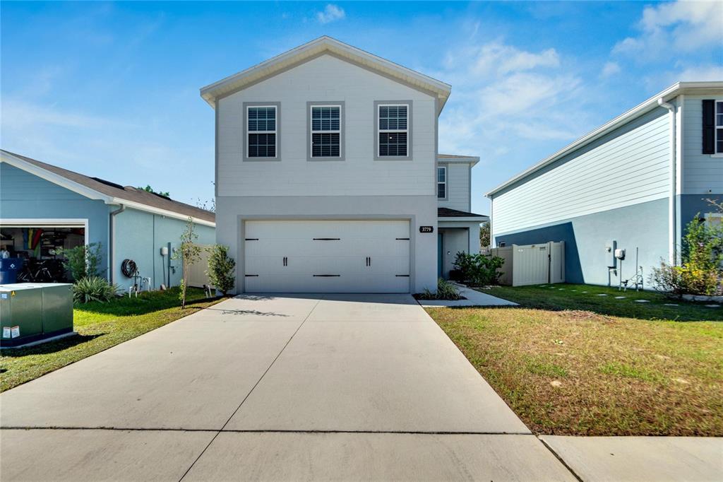 a front view of a house with a yard and garage