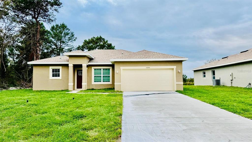 a front view of a house with yard and green space