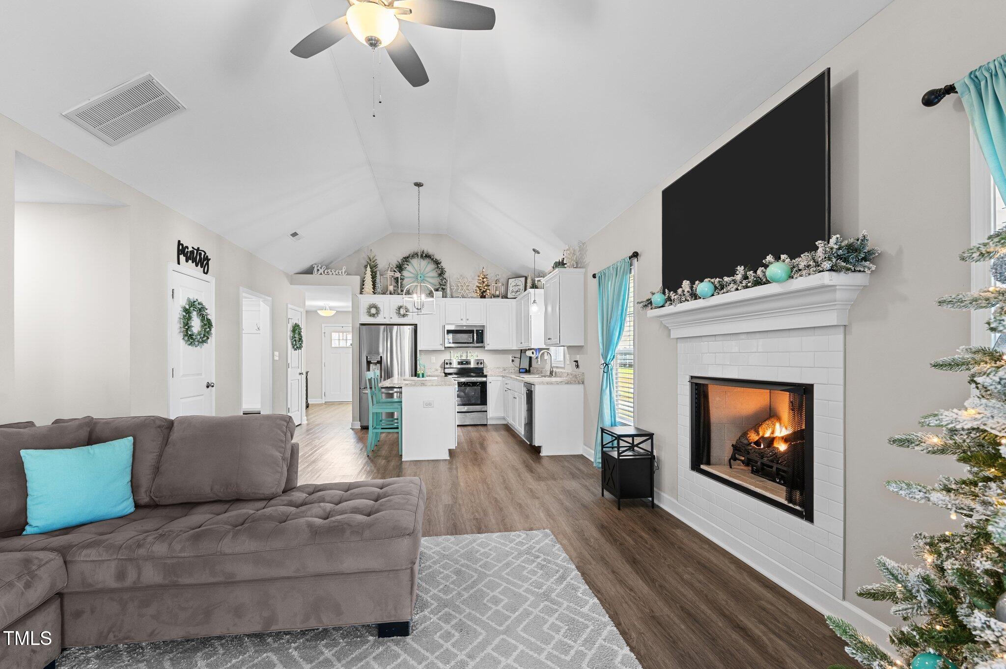 a living room with furniture a flat screen tv and a fireplace