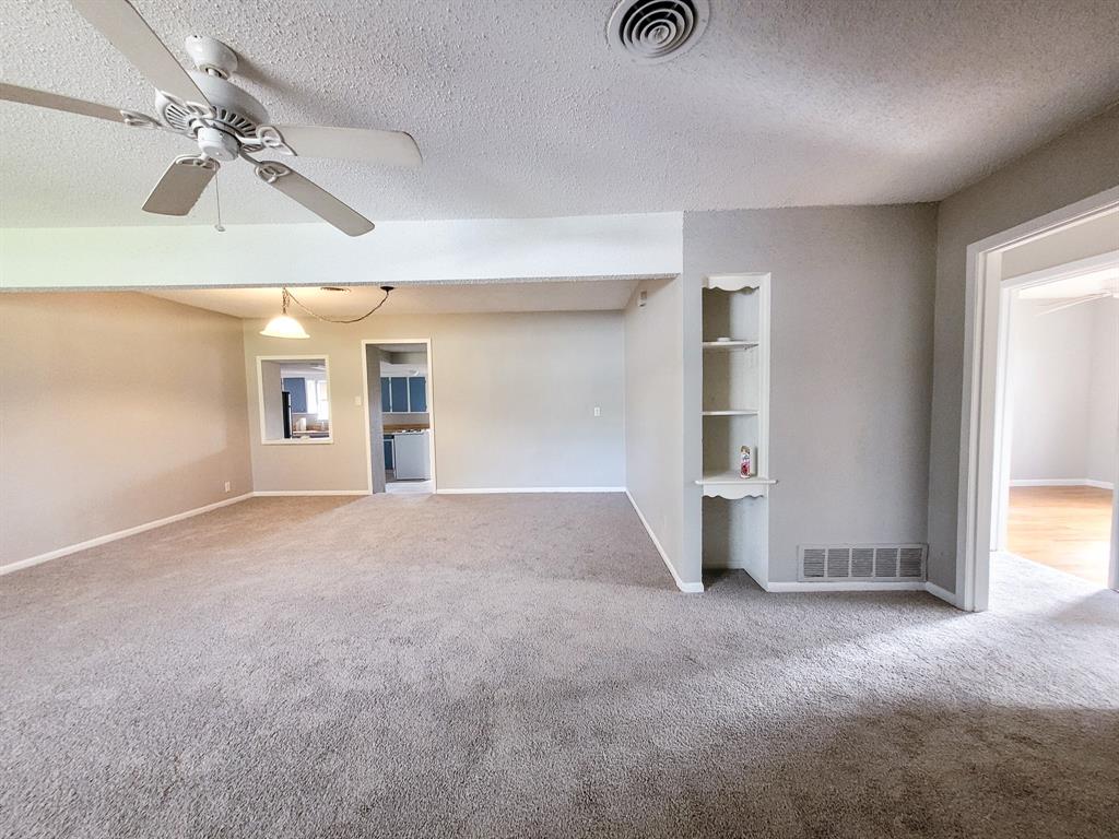 a view of empty room with windows and ceiling fan