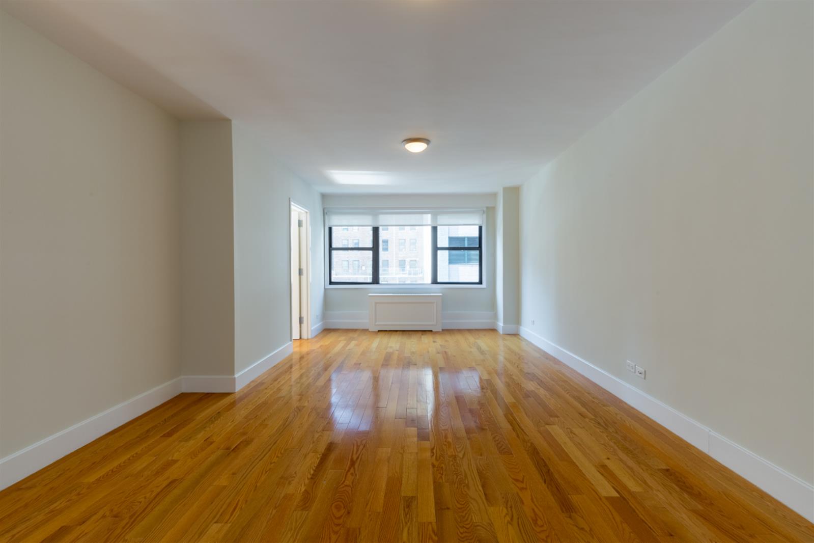 wooden floor in an empty room with a window