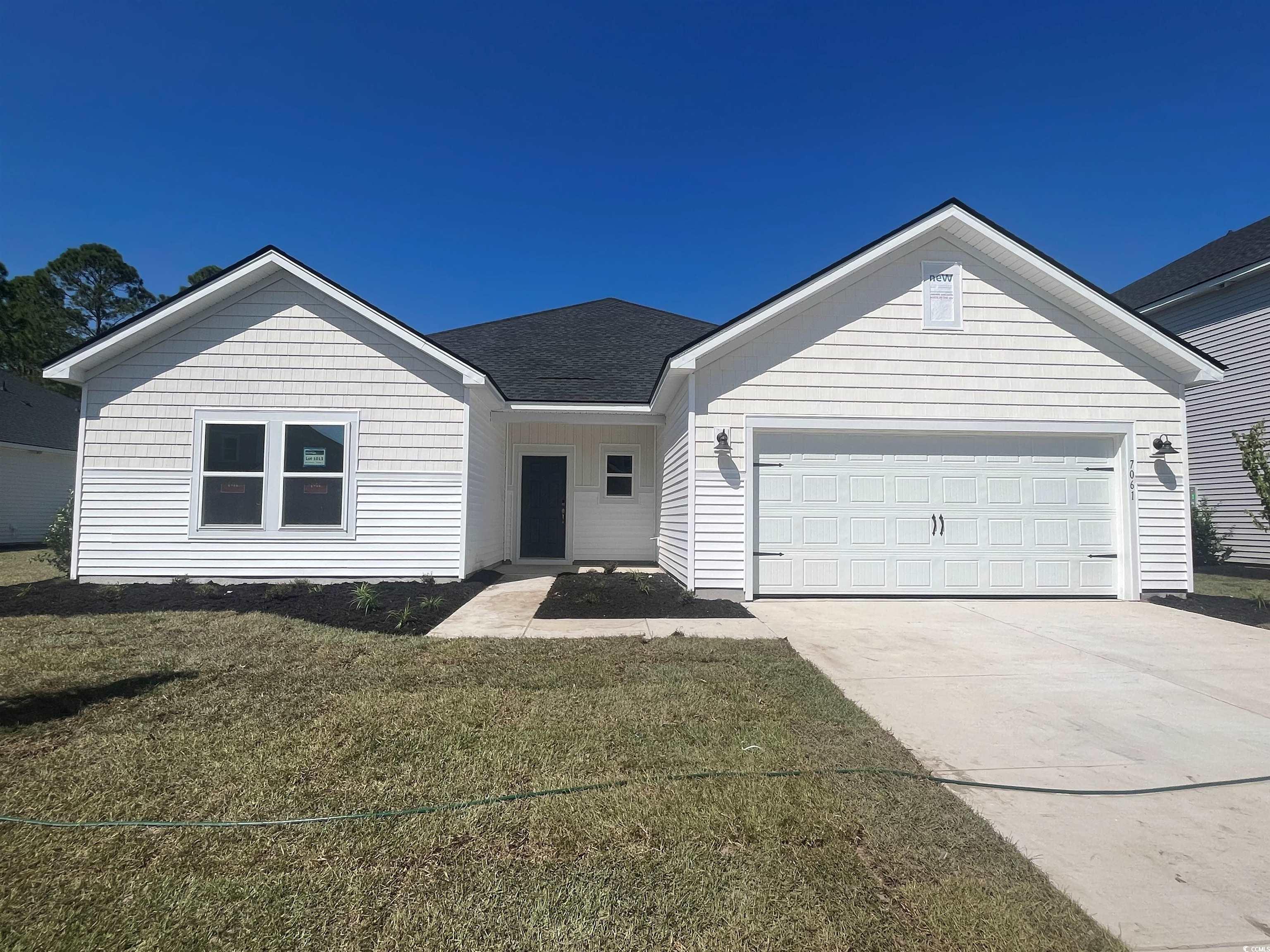 Single story home featuring a front yard and a gar