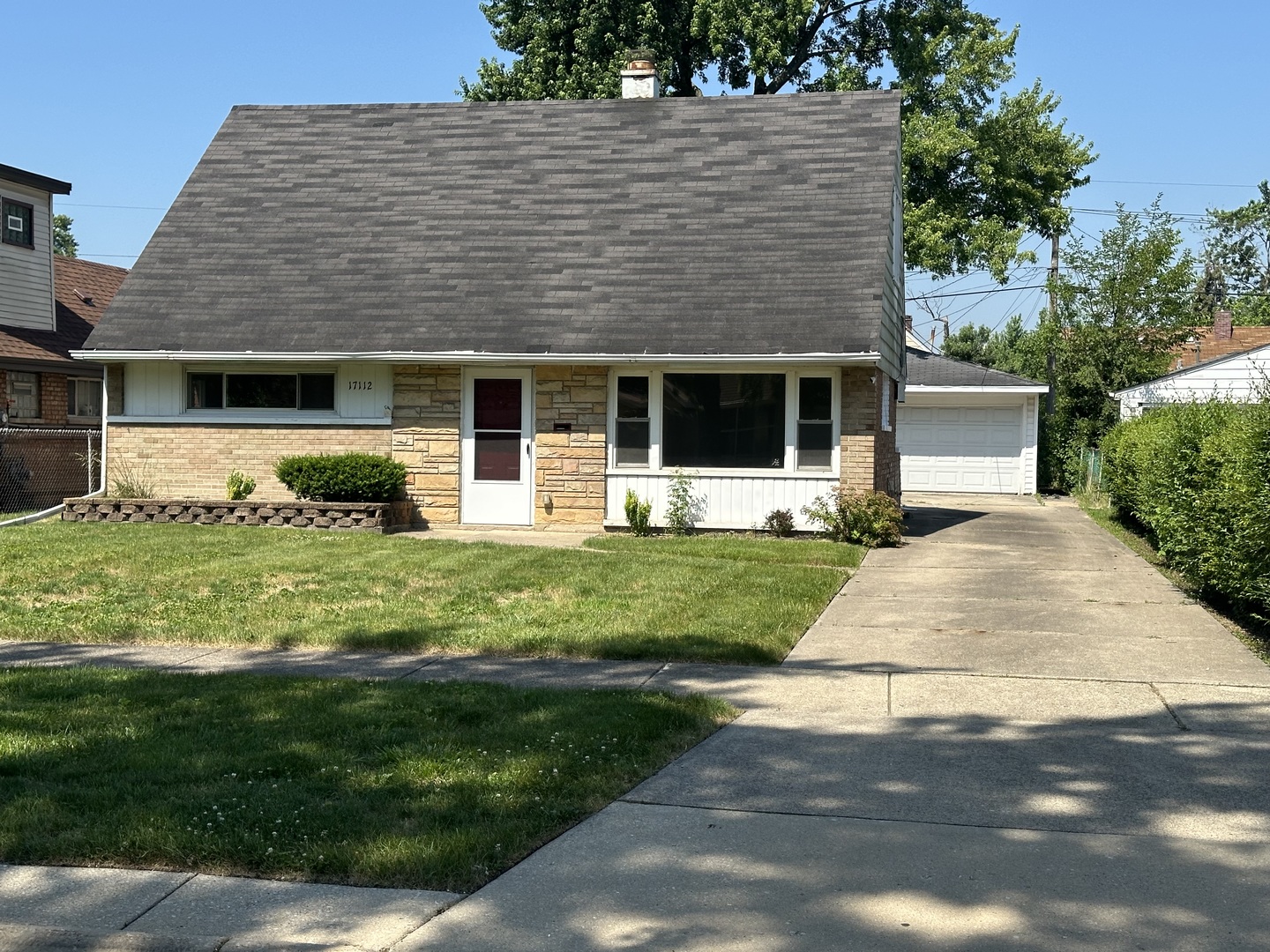 a front view of a house with a yard and potted plants