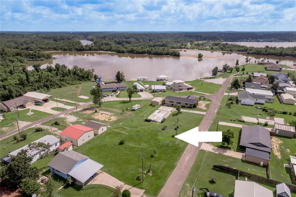 an aerial view of residential houses with outdoor space and lake view