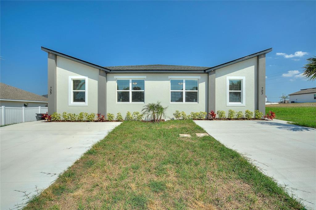 a front view of a house with yard patio and outdoor seating