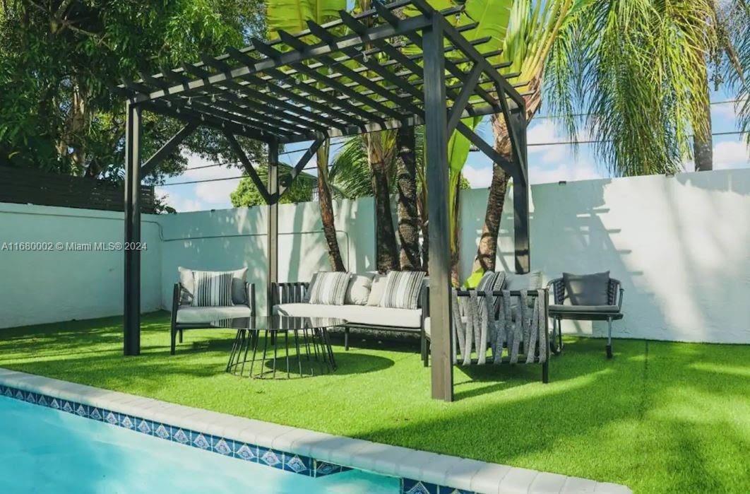 a view of backyard with a table and chairs and a large tree