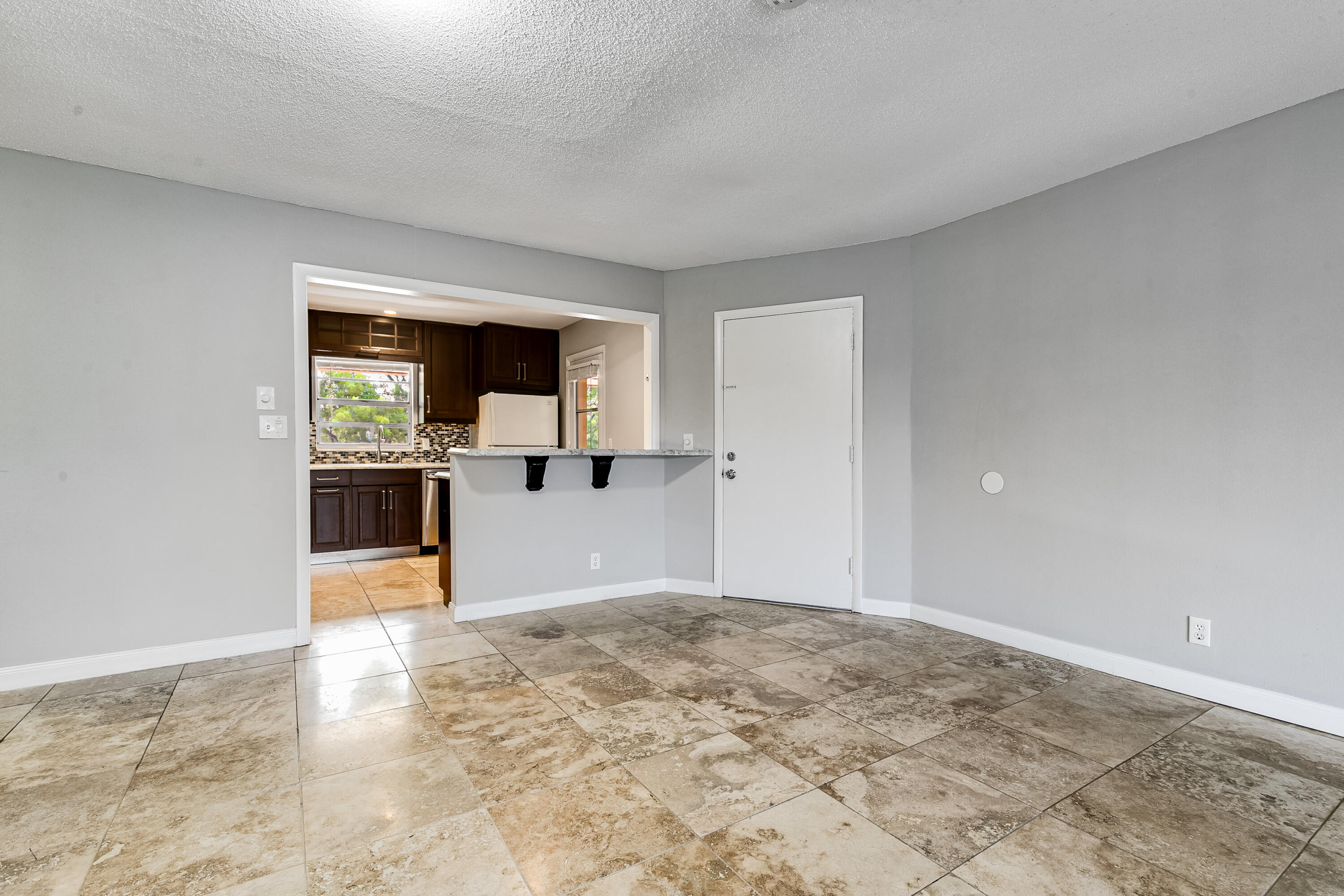 a view of a big room with wooden floor and a kitchen