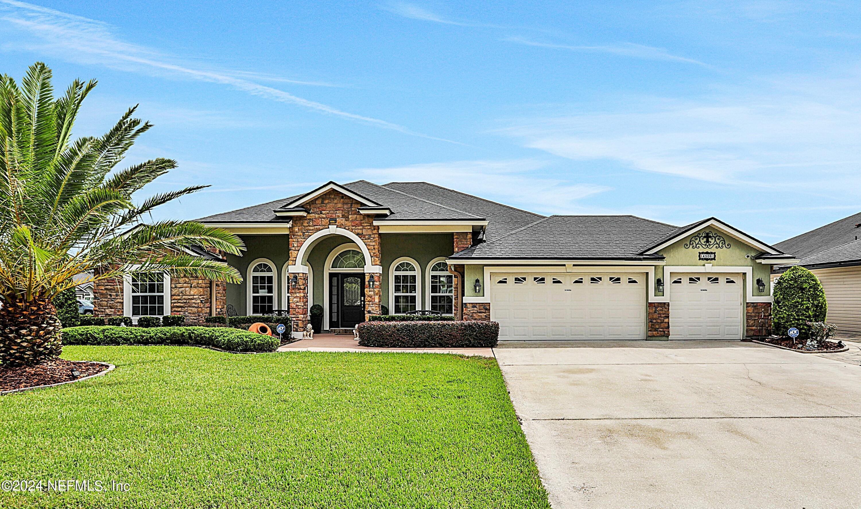 a front view of a house with a garden and trees