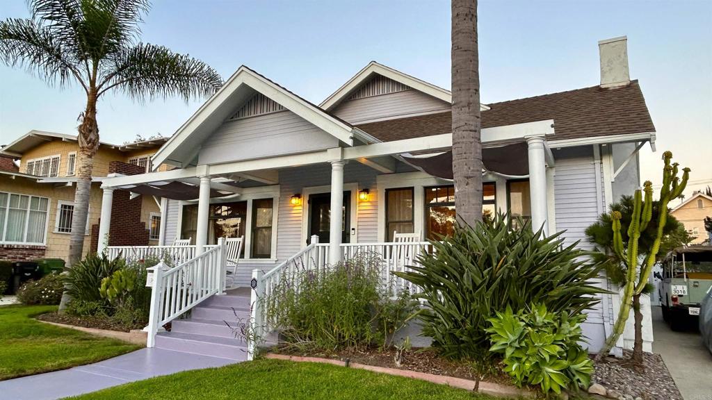 a front view of a house with a yard and potted plants