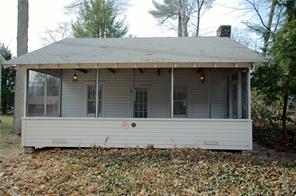 a view of wooden house with a bench