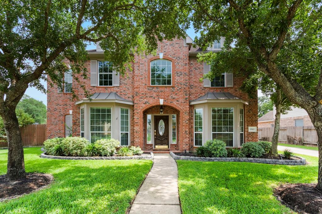 front view of a brick house with a yard