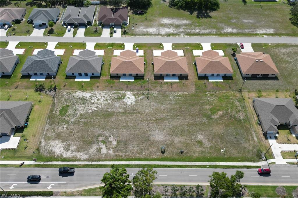 an aerial view of residential houses with outdoor space and parking