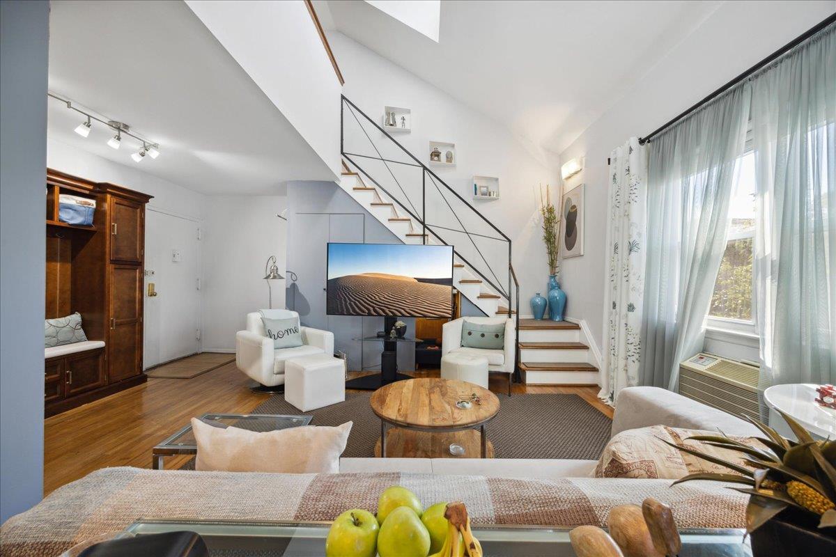 Living room featuring wood-type flooring and lofted ceiling