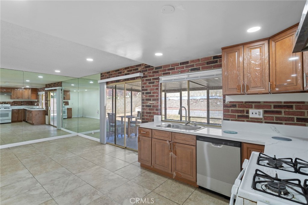 a open kitchen with kitchen island granite countertop a sink stove and cabinets