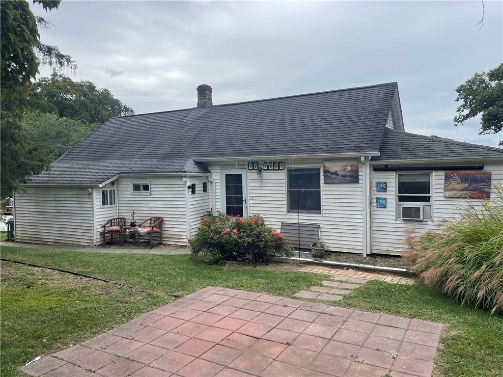 Rear view of house featuring a lawn and a patio