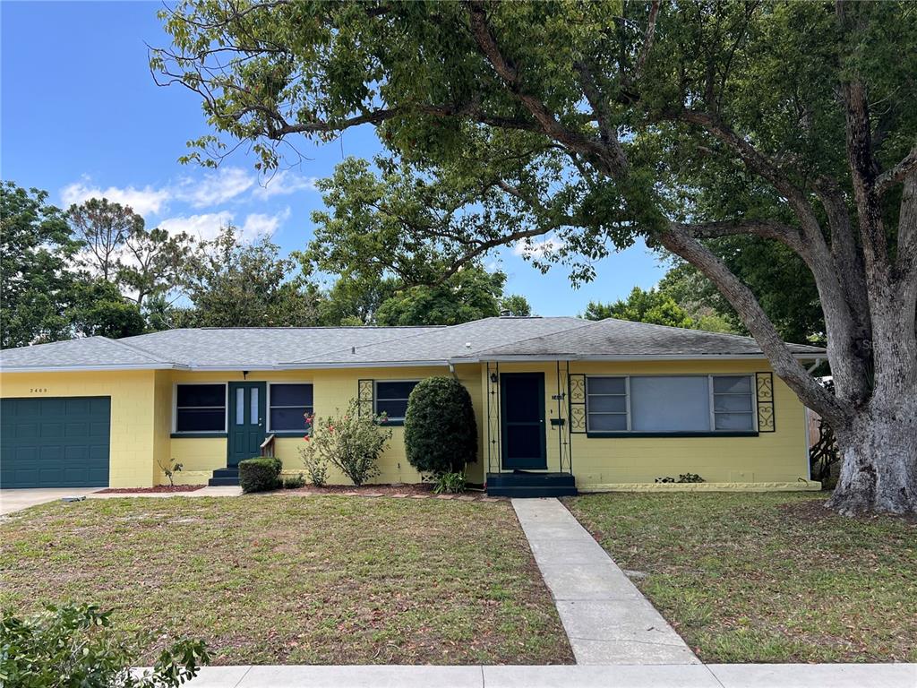 a view of a house with a tree in front of it