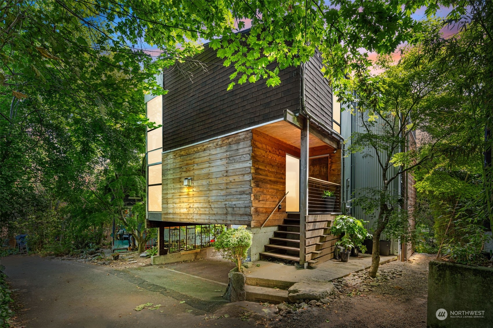 a view of house with a tree and wooden fence