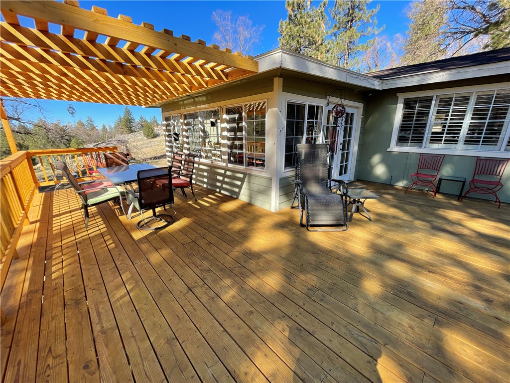 a view of a patio with table and chairs with wooden floor and fence