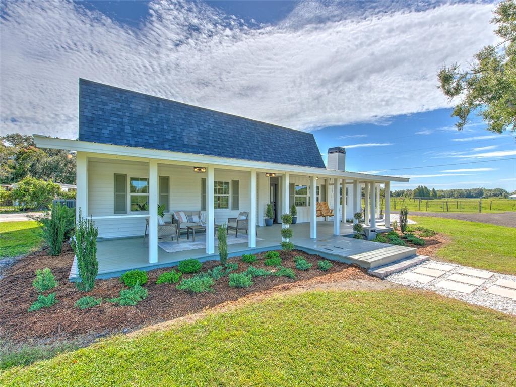 a front view of a house with a yard and outdoor seating