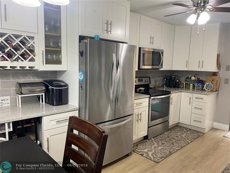 a kitchen with a stove refrigerator and microwave