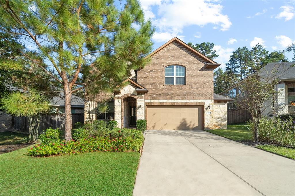 a front view of a house with a yard and trees