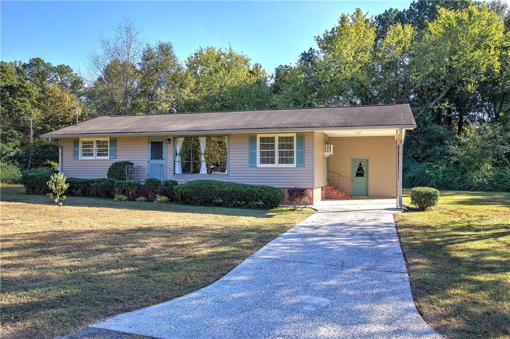 a front view of house with yard and trees around