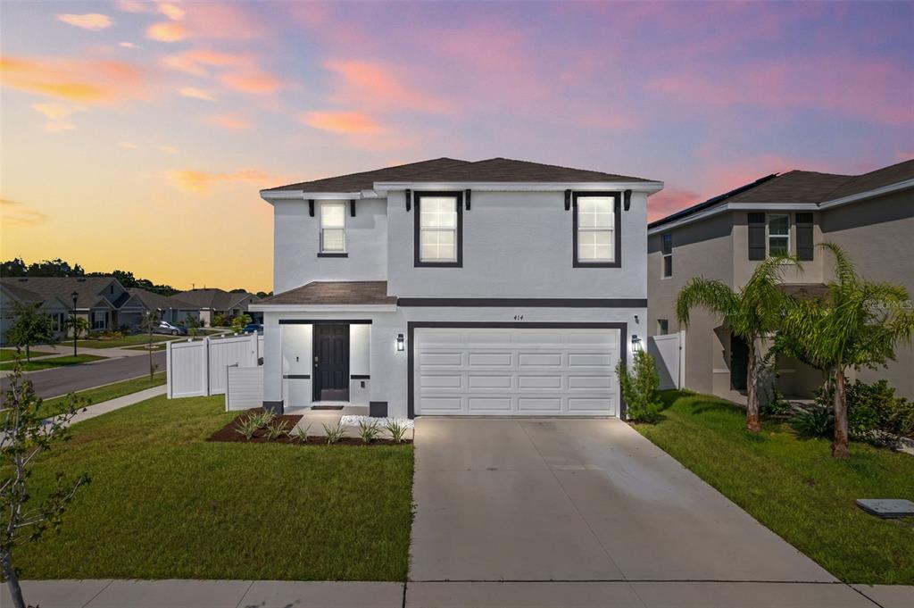 a front view of a house with a yard and garage