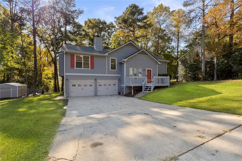 a front view of a house with a yard and trees