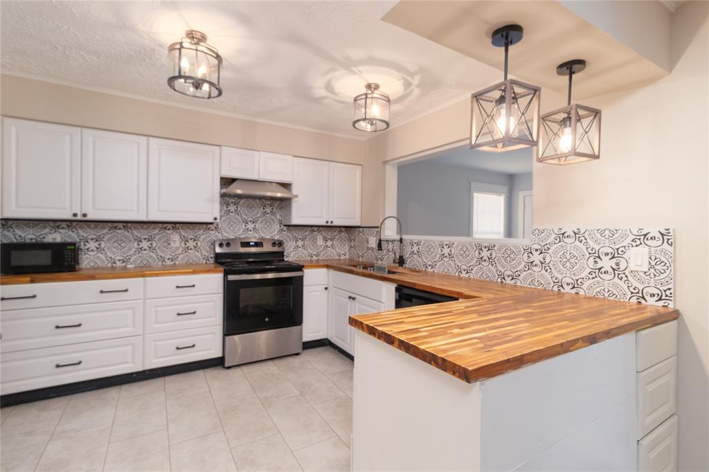 a kitchen with a stove and white cabinets