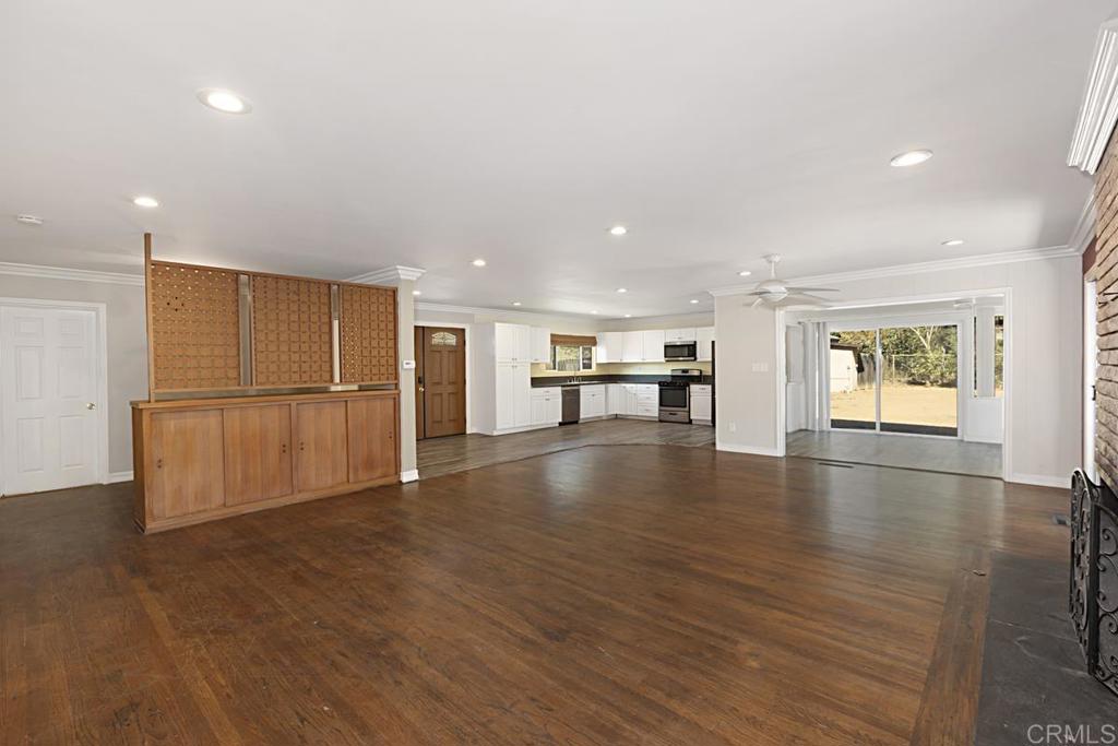 a view of empty room with wooden floor and windows