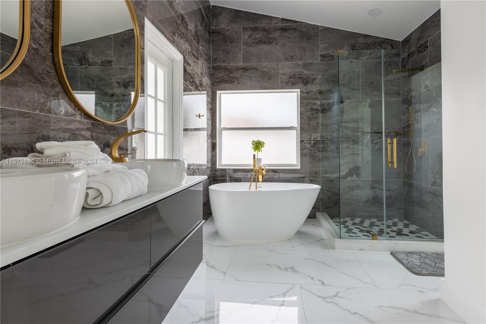 a white bath tub sitting next to a bathroom sink