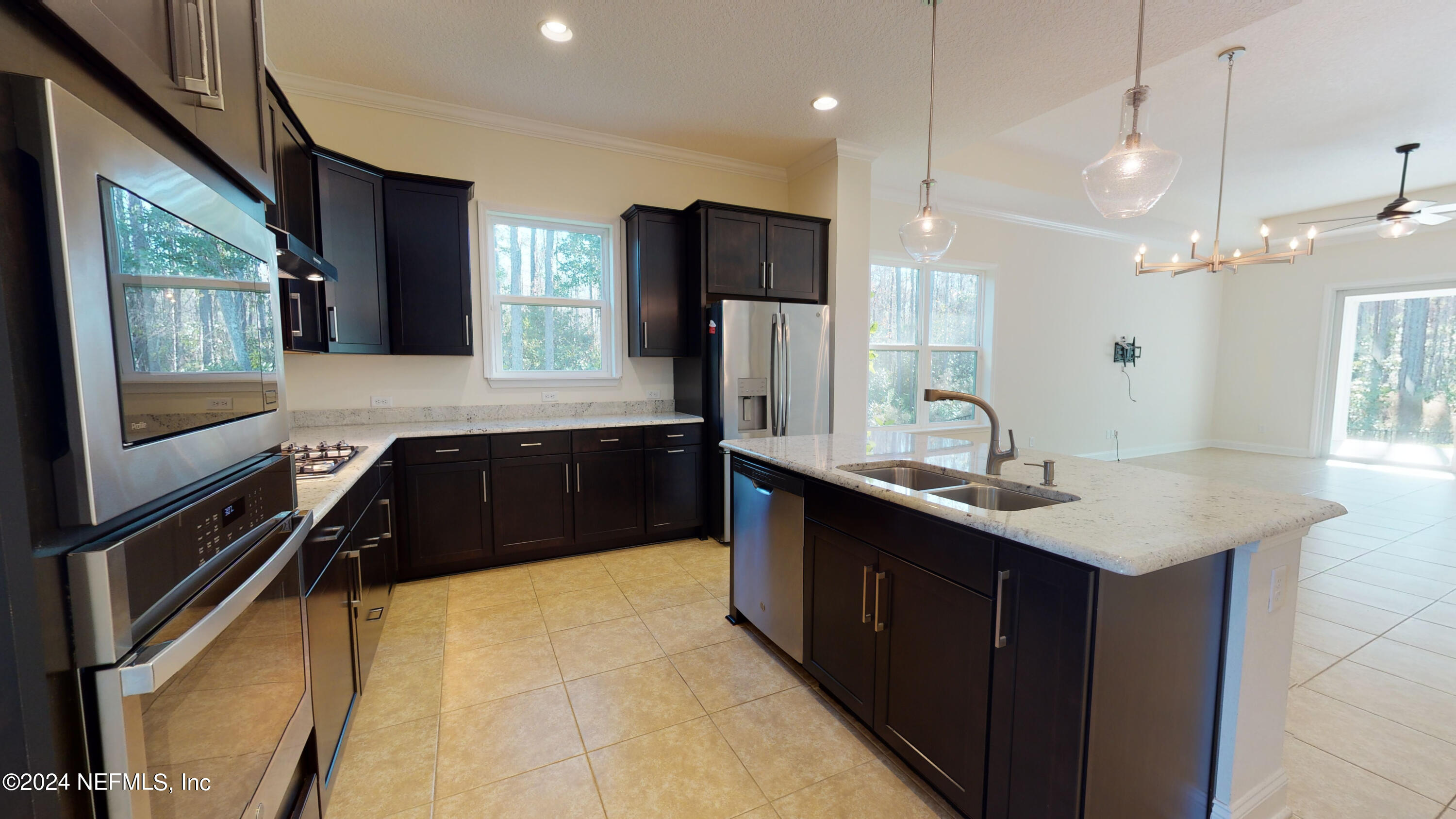 a large kitchen with granite countertop a sink and a refrigerator