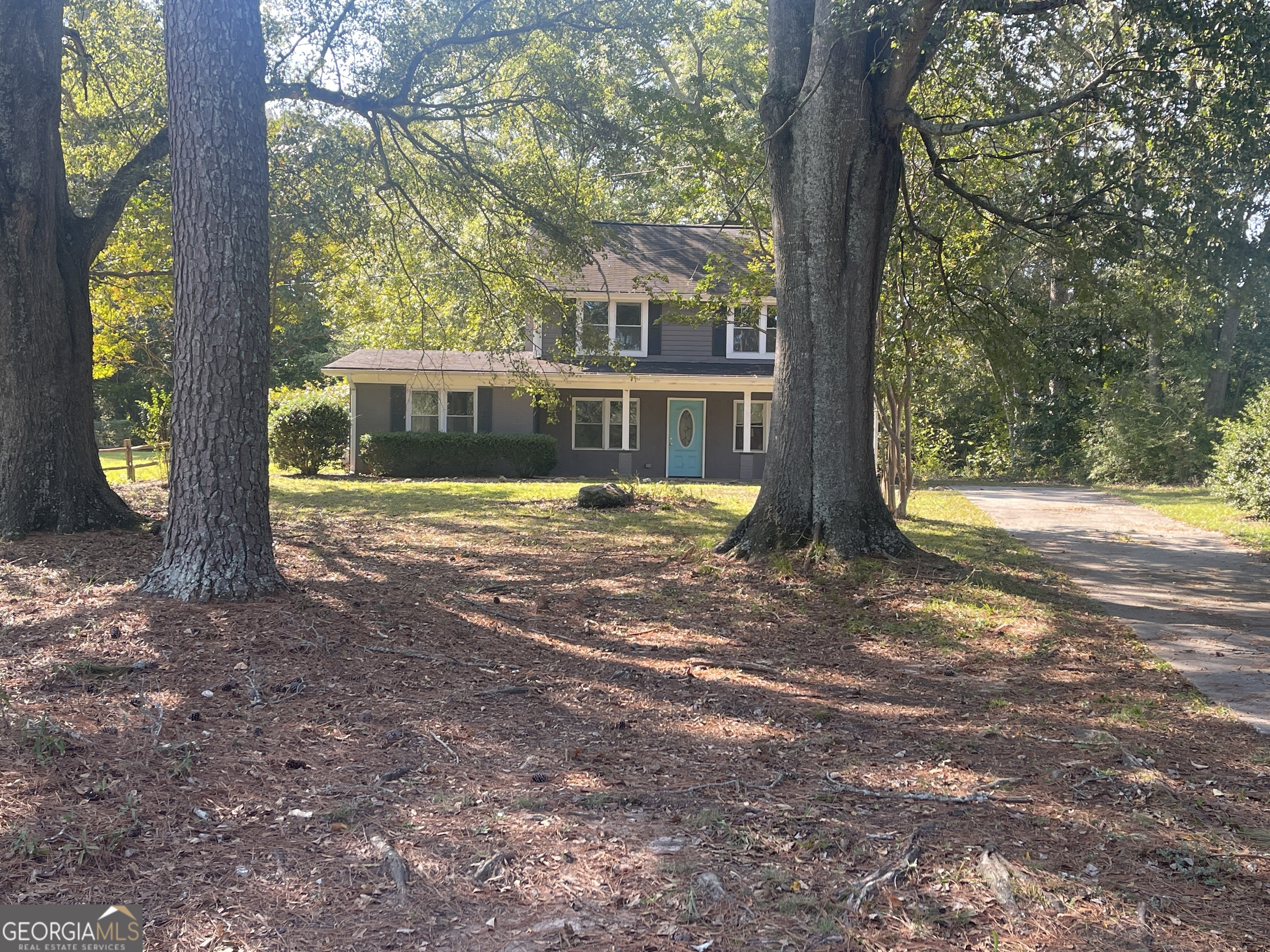 a view of a house with backyard and tree