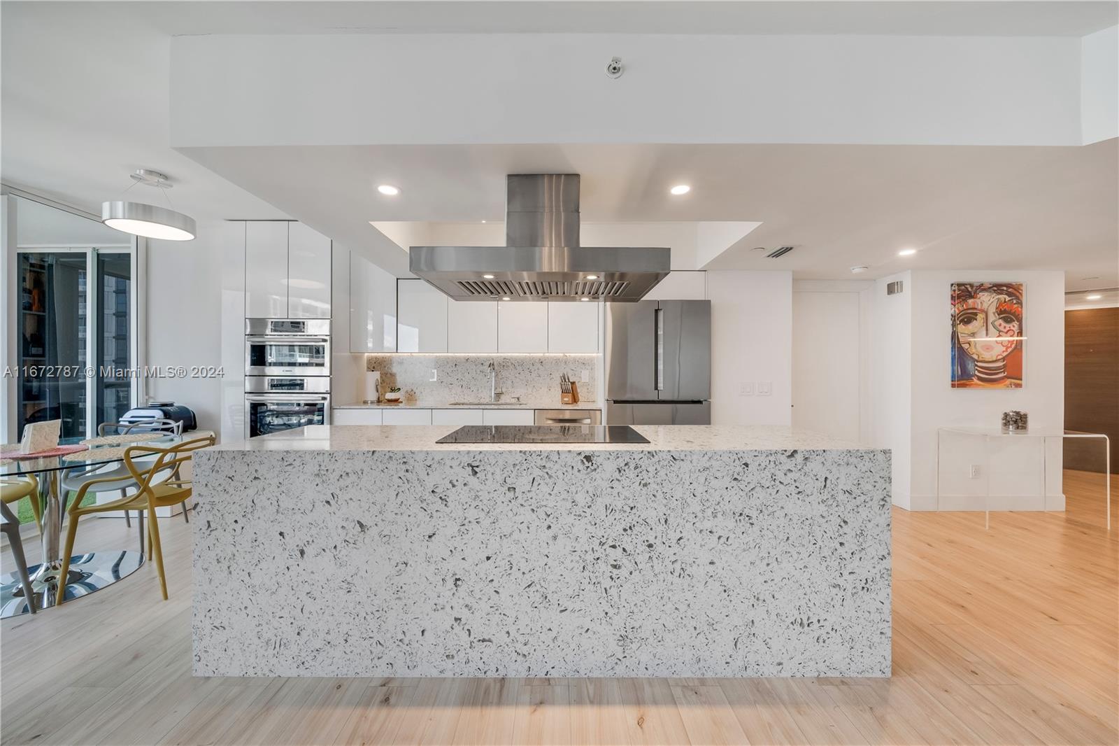 a large kitchen with kitchen island a stove a table and chairs in it