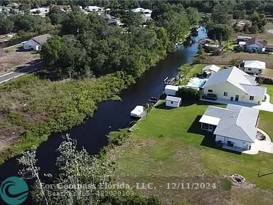 an aerial view of a house with yard swimming pool and lake view