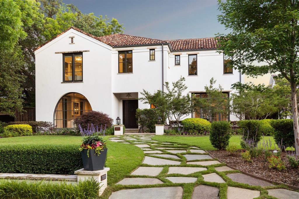 a front view of a house with a garden and plants