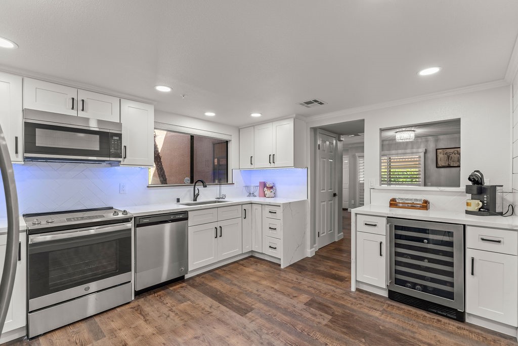 a kitchen with granite countertop a sink cabinets and stainless steel appliances