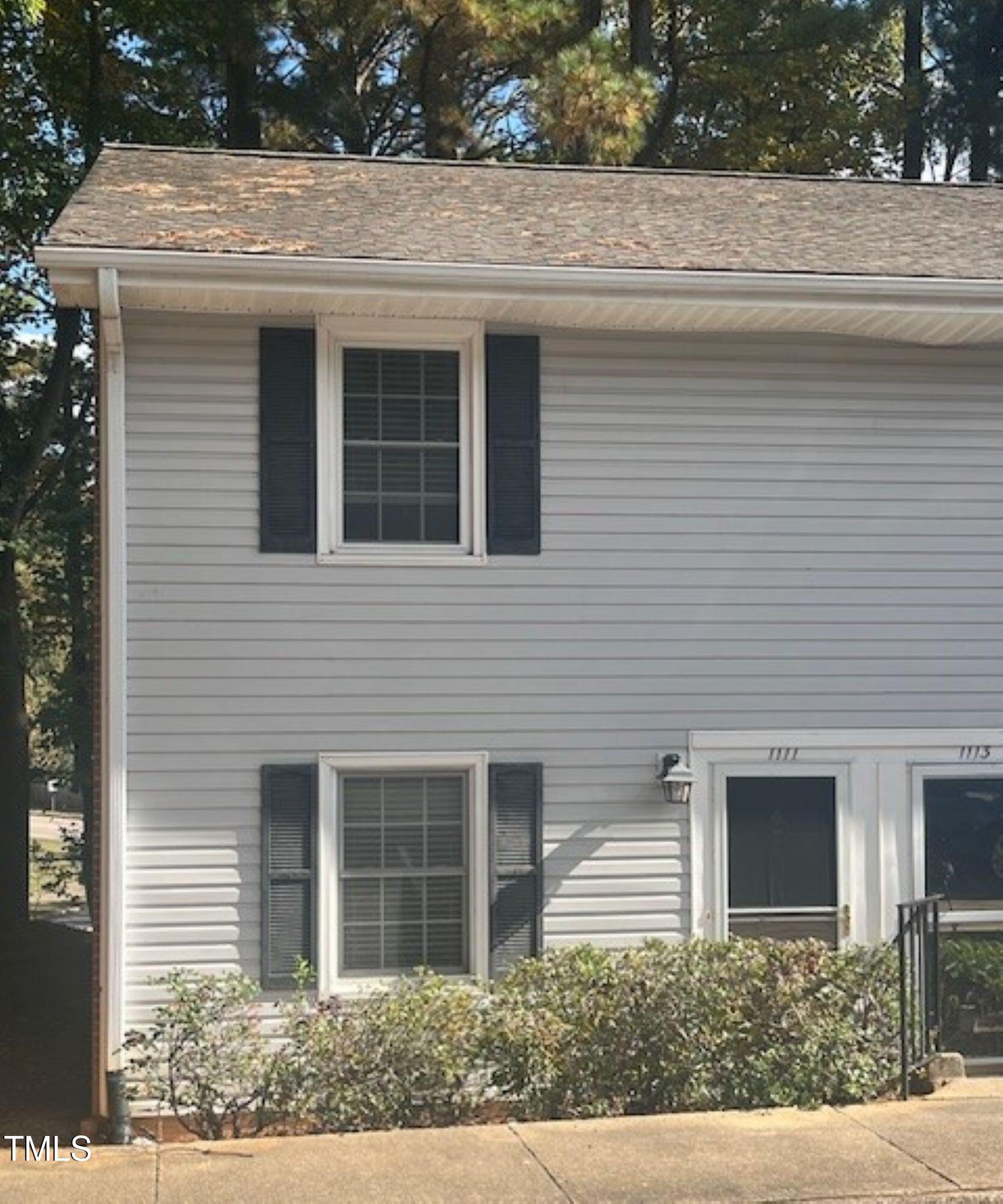 a front view of a house with plants