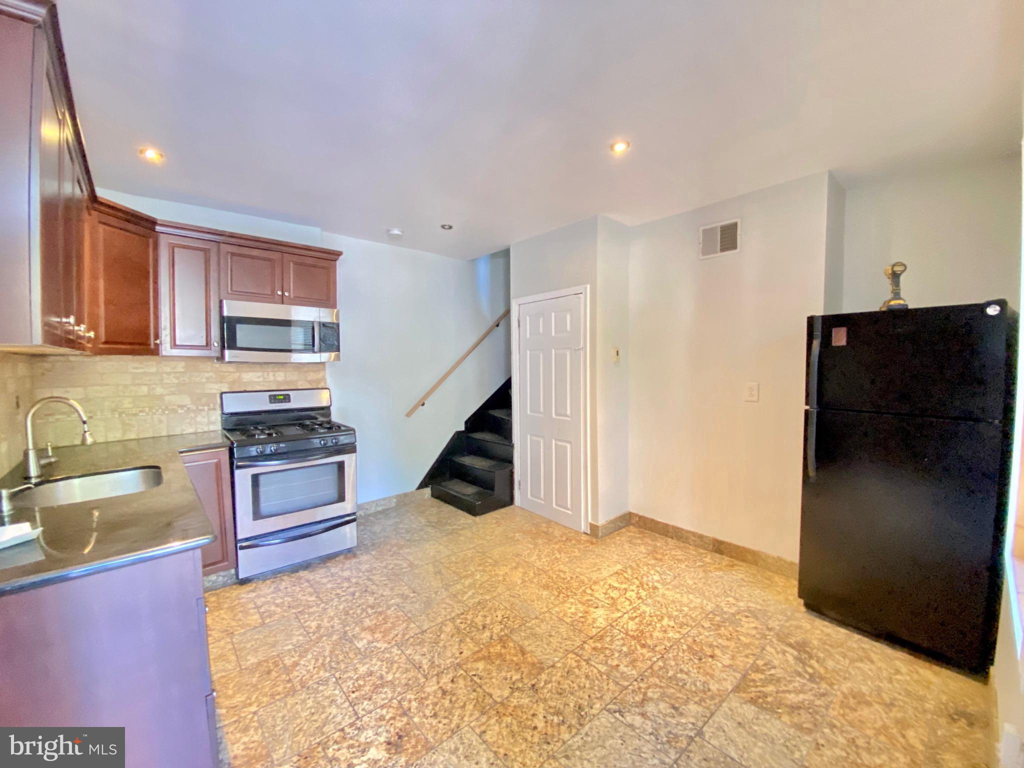 a kitchen with stainless steel appliances granite countertop a refrigerator and a sink