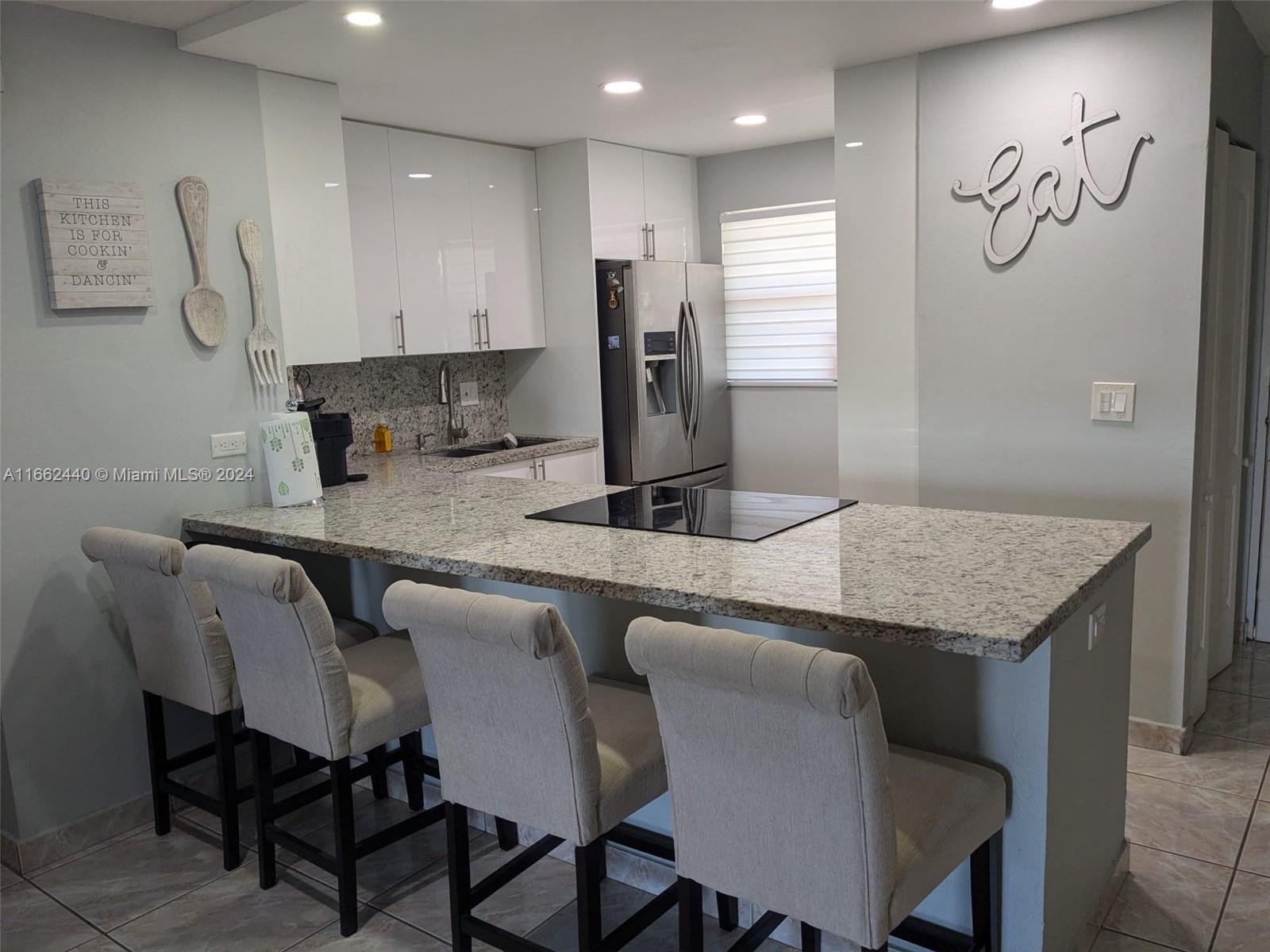 a kitchen with granite countertop sink table and chairs