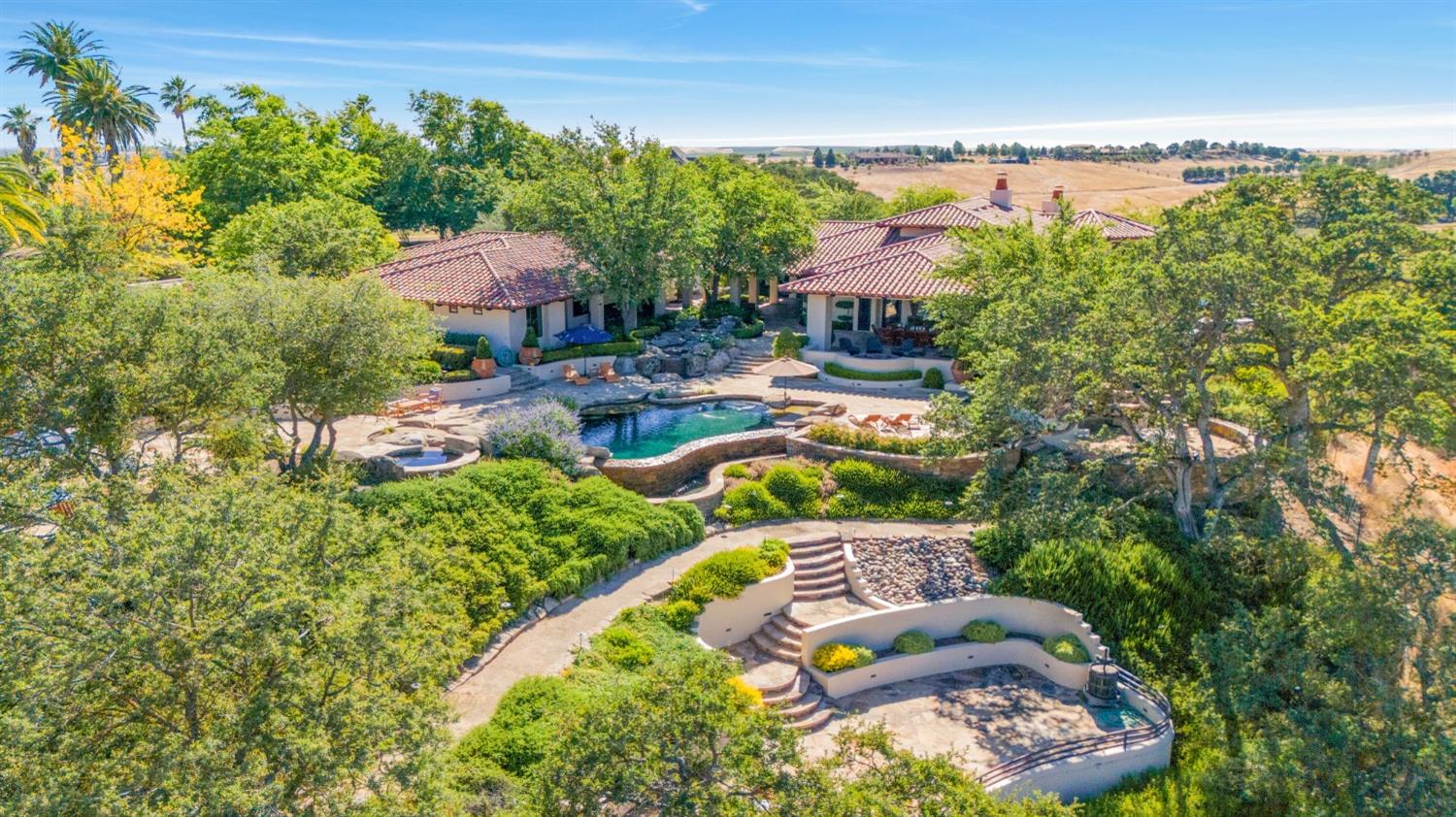 an aerial view of a house with a garden and lake view