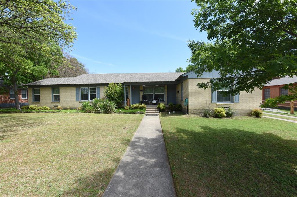 a front view of a house with a yard and trees