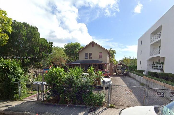 a view of a street with potted plants and a bench