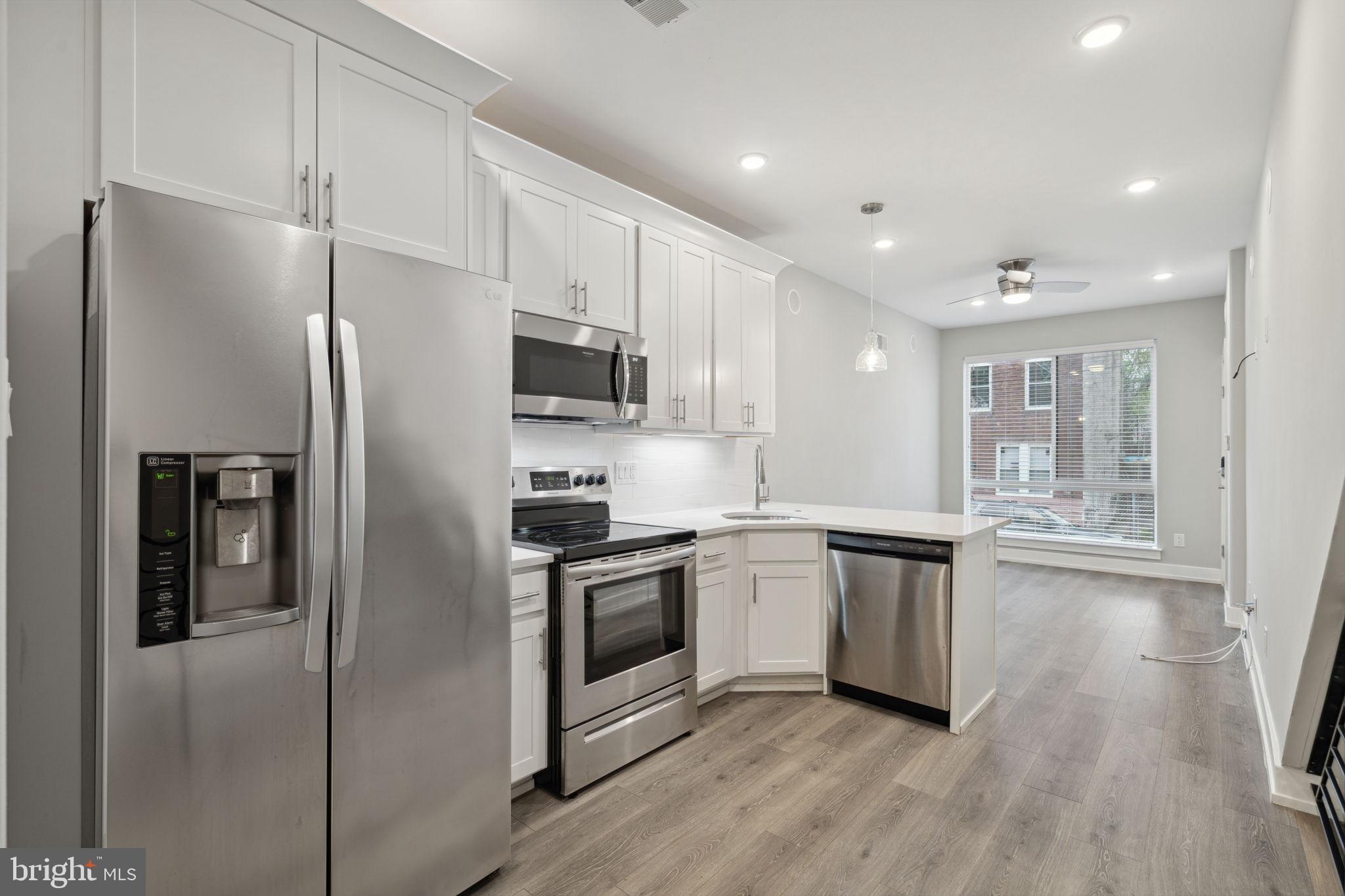 a kitchen with stainless steel appliances granite countertop a refrigerator and a stove top oven