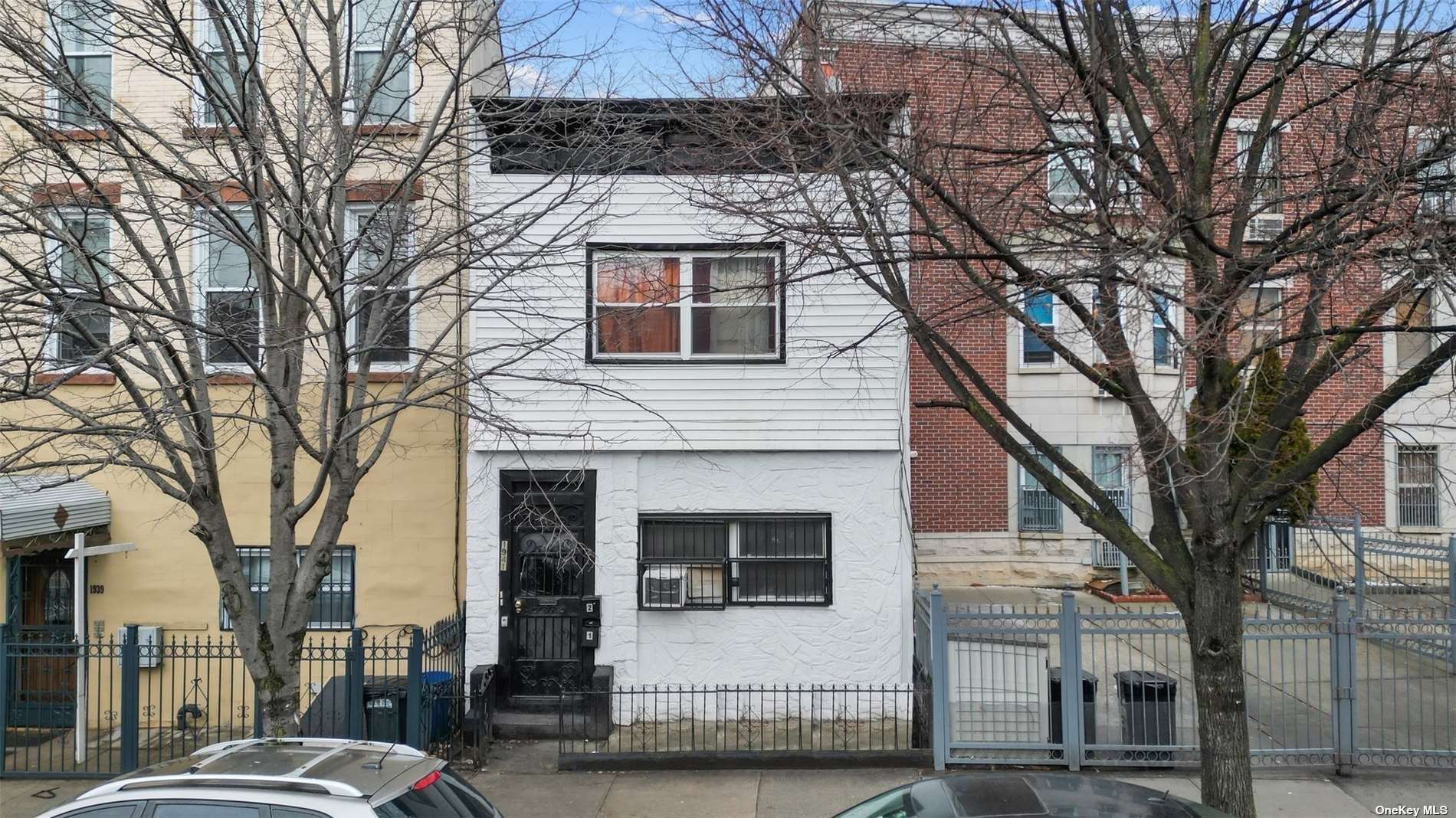 a front view of a house with a tree