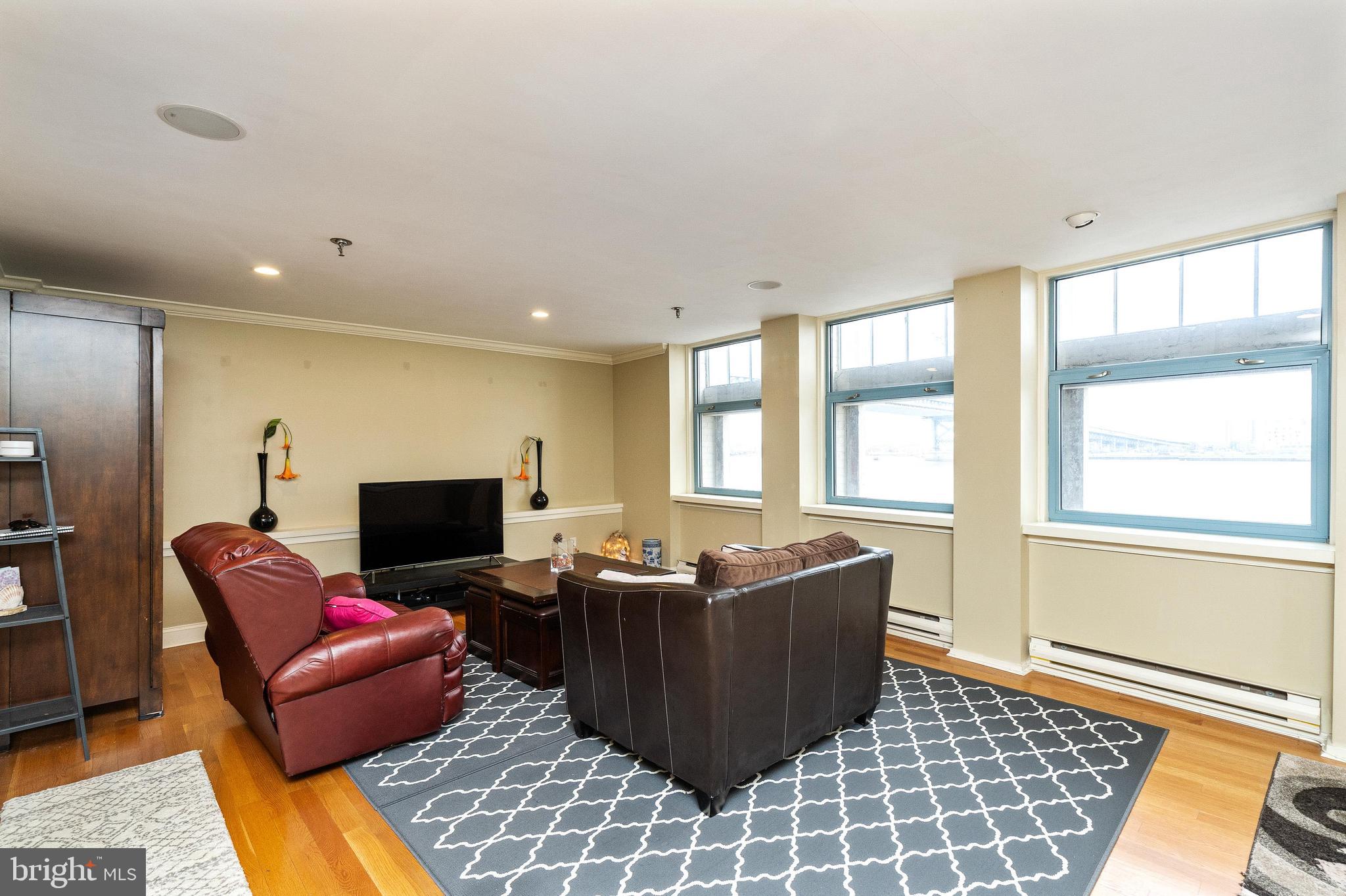 a living room with furniture a flat screen tv and a window