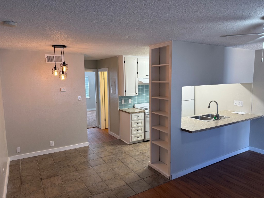 a kitchen with a sink refrigerator and cabinets