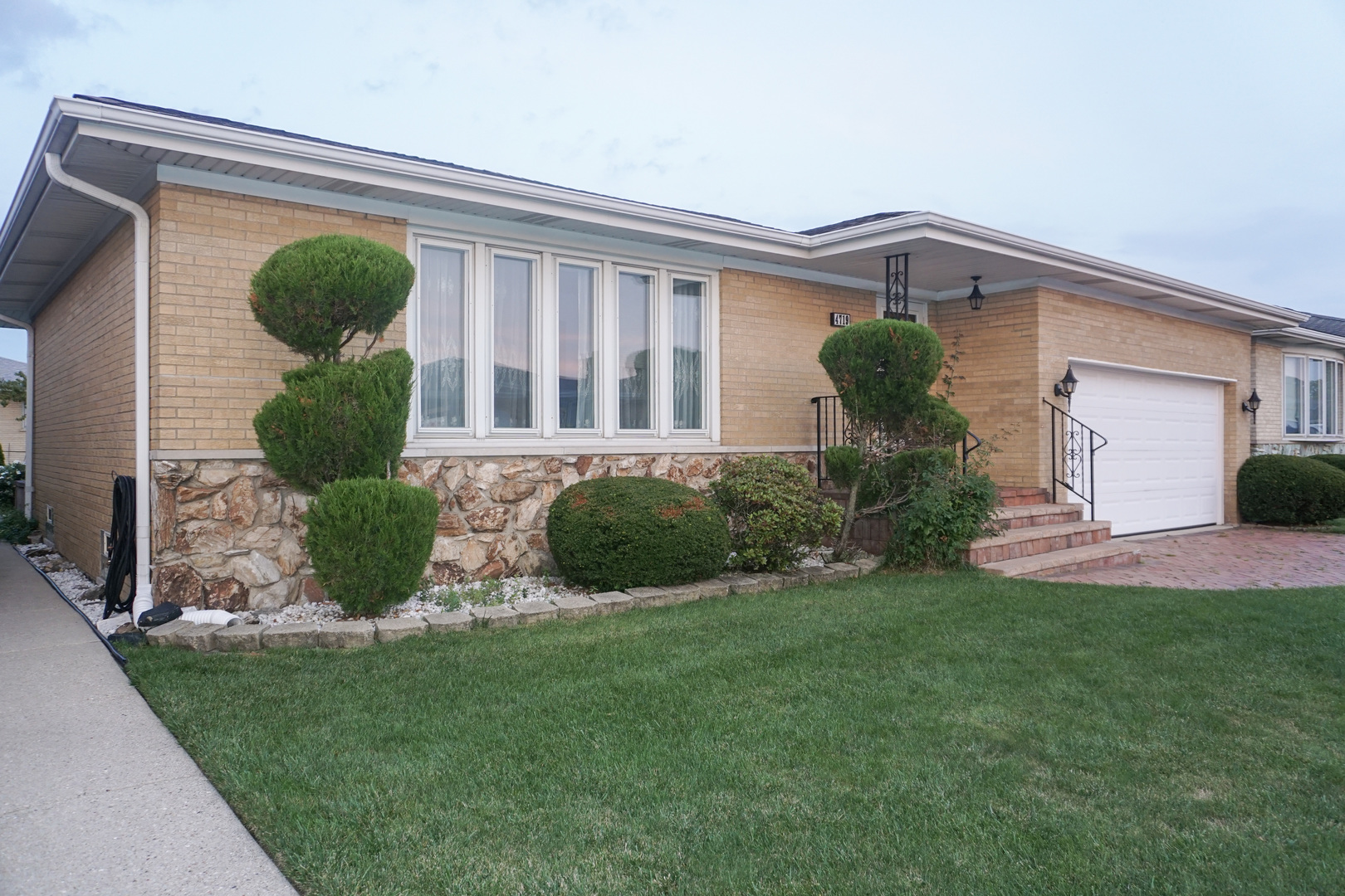 a front view of a house with porch and a fountain