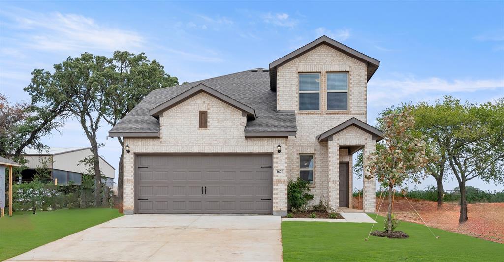 a front view of a house with a yard and garage